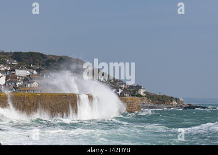 Mousehole, Cornwall, UK. 13 avr, 2019. Météo britannique. Des vents de 50km/h, et de grosses vagues batter le mur du port à Mousehole ce midi. Malgré le vent, il était toujours ensoleillé. Crédit : Simon Maycock/Alamy Live News Banque D'Images