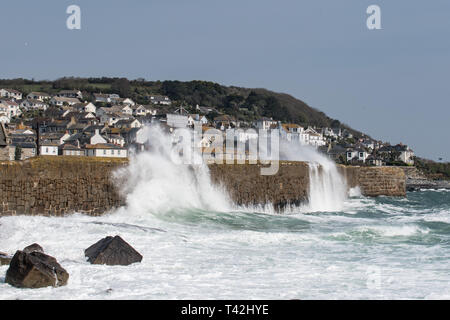 Mousehole, Cornwall, UK. 13 avr, 2019. Météo britannique. Des vents de 50km/h, et de grosses vagues batter le mur du port à Mousehole ce midi. Malgré le vent, il était toujours ensoleillé. Crédit : Simon Maycock/Alamy Live News Banque D'Images