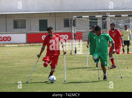 Gaza, la Palestine. 13 avril, 2019. - La ville de Gaza, en Palestine, le 13 avril 2019. En utilisant des béquilles amputés palestiniens jouent au football dans la ville de Gaza lors d'un tournoi organisé par le Comité international de la Croix-Rouge dans la bande de Gaza. La compétition comprenait 80 joueurs qui jouent dans des équipes différentes, y compris 20 joueurs blessés au cours de la grande marche du retour des rassemblements. Selon des responsables palestiniens plus de 6 500 personnes ont été tuées par balle par les forces israéliennes au cours d'une année de manifestations de masse hebdomadaires le long de la frontière de Gaza, avec beaucoup d'entre eux ayant besoin d'amputations. D'autres joueurs de rejoindre le football pour Banque D'Images