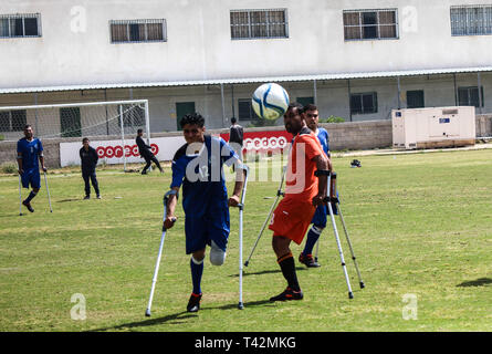 Gaza, la Palestine. 13 avril, 2019. - La ville de Gaza, en Palestine, le 13 avril 2019. En utilisant des béquilles amputés palestiniens jouent au football dans la ville de Gaza lors d'un tournoi organisé par le Comité international de la Croix-Rouge dans la bande de Gaza. La compétition comprenait 80 joueurs qui jouent dans des équipes différentes, y compris 20 joueurs blessés au cours de la grande marche du retour des rassemblements. Selon des responsables palestiniens plus de 6 500 personnes ont été tuées par balle par les forces israéliennes au cours d'une année de manifestations de masse hebdomadaires le long de la frontière de Gaza, avec beaucoup d'entre eux ayant besoin d'amputations. D'autres joueurs de rejoindre le football pour Banque D'Images