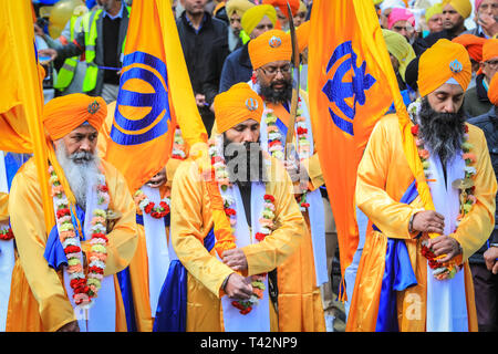 Gravesend, Kent, Royaume-Uni, 13 avril 2019. Les cinq Sikh hommes qui représentent le Panj Pyare (cinq bien-aimés), à l'avant de la procession, suivis du flotteur contenant le sanctuaire. Les participants sikhs portent le kirpan traditionnel, un poignard ou une épée, et le turban. Des milliers de spectateurs et de visiteurs religieux bordent les rues de Gravesend dans le Kent pour observer et participer à la procession annuelle de Vaisakhi. Vaisakhi est célébré par la communauté sikh partout dans le monde. Banque D'Images