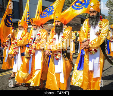 Gravesend, Kent, Royaume-Uni, 13 avril 2019. Les cinq Sikh hommes qui représentent le Panj Pyare (cinq bien-aimés), à l'avant de la procession, suivis du flotteur contenant le sanctuaire. Les participants sikhs portent le kirpan traditionnel, un poignard ou une épée, et le turban. Des milliers de spectateurs et de visiteurs religieux bordent les rues de Gravesend dans le Kent pour observer et participer à la procession annuelle de Vaisakhi. Vaisakhi est célébré par la communauté sikh partout dans le monde. Banque D'Images