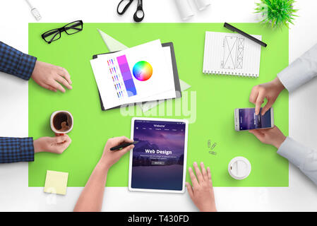 Équipe de conception Web conférence sur nouveau projet web pour le client. Haut de la vue, télévision mise scène avec tablette, téléphone intelligent, beaucoup de café et des documents. Banque D'Images