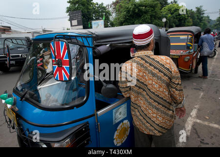 Dans l'homme chemise batik bleu, à côté de la gare, à l'extérieur de bajaj France district, Jakarta, Indonésie Banque D'Images