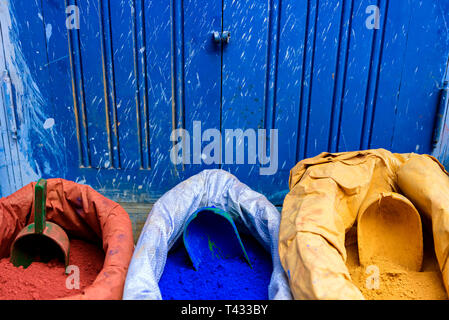 Sacs de poudre de couleur (pigment de peinture en poudre) dans des couleurs primaires contre fond bleu Banque D'Images