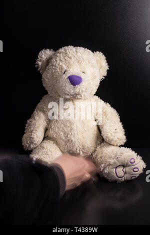 Fait à la main personnalisé blanc Ours en peluche avec nez violet sur fond sombre Banque D'Images