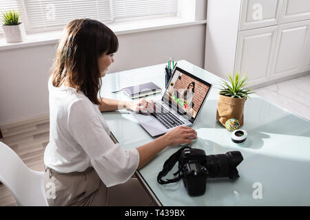 Businesswoman Using Laptop Conférence vidéo avec votre appareil photo reflex numérique sur 24 sur le lieu de travail Banque D'Images
