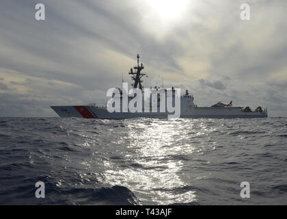 Une station d'Air Point MH-65 barbiers équipages d'Dolphin se prépare à décoller de l'envol du les garde-côte de Munro (WMSL 755) dans l'océan Pacifique, 04 déc., 2018. L'équipage de la faucheuse effectuait sa première patrouille opérationnelle des commanditaires en Océanie. (U.S. Photo de la Garde côtière canadienne par le maître de 3e classe Matthew West/libérés) Banque D'Images