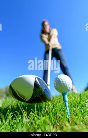 Joueur de golf féminin de frapper une balle avec chauffeur Banque D'Images