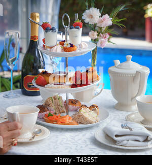 Un gros plan d'un haut plateau sur un cake stand servi avec une bouteille de fizz de la piscine Banque D'Images