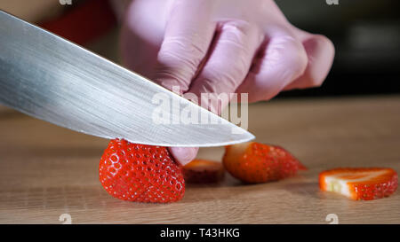 Gros plan du chef cuire les fraises sur une planche à découper Banque D'Images