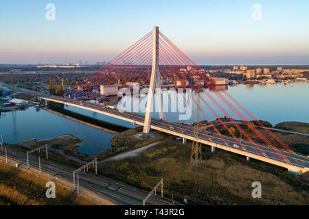 Gdansk, Pologne. Autoroute moderne pont à haubans sur la rivière Vistule morte et le chemin de fer.. Vue aérienne au coucher du soleil la lumière. Port du nord loin dans la ba Banque D'Images