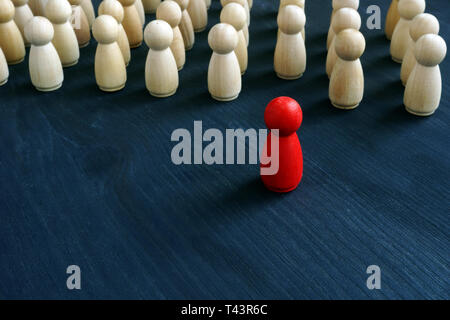 Figurine rouge en face de ligne comme symbole de leadership. Se démarquer de la foule. Banque D'Images