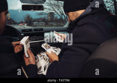 Après le succès du vol de banque, les voleurs sont dans la voiture montrant outre de leur argent et de célébrer la victoire sur le droit qu'ils avaient. Banque D'Images