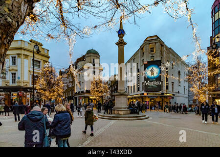 Illuminations de Noël à Seven Dials, avec des amateurs de shopping et des visiteurs passant devant le Cambridge Theatre, montrant Matilda the musical , Londres, Royaume-Uni Banque D'Images