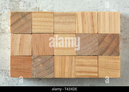 Vue de dessus - 15 petits cubes en bois disposées à 3 x 5, sur du béton de la grille de sélection. Les lettres peuvent être ajoutés. Banque D'Images