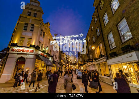 Les amateurs de shopping et les visiteurs marchant dans les rues animées de Seven Dials à Noël, Londres, Royaume-Uni Banque D'Images