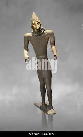 La figure de bronze Hittite avec un masque, Période Hittite. Musée Archéologique d'Adana, Turquie. Contre un art fond gris Banque D'Images