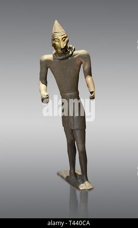 La figure de bronze Hittite avec un masque, Période Hittite. Musée Archéologique d'Adana, Turquie. Sur un arrière-plan gris Banque D'Images