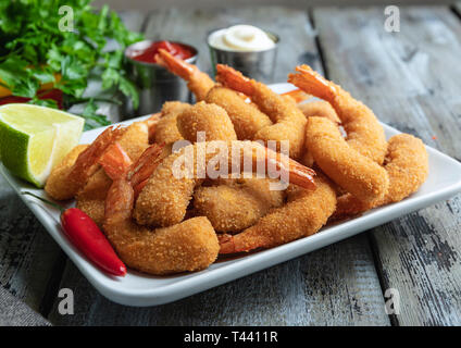 Les moules, crevettes pané frit servi avec de la chaux sur planche de bois, de délicieux, profonde rouge, la sauce blanche Banque D'Images