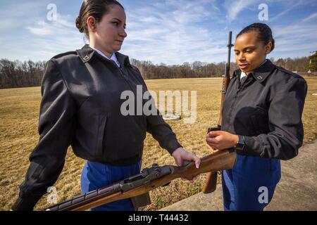 Circuit de l'armée américaine. Kim G. Hayden, gauche, présente son fusil M-14 pour l'inspection des armes à feu commandant parti PFC. Janee S. plus simple, les deux membres de la Garde nationale du New Jersey, de la garde d'honneur pendant trois-soldat tirant partie de la formation au terrain de parade à la Garde nationale Armory à Lawrenceville, New Jersey), 14 mars 2019. Au cours de cette pratique, les soldats ont examiné la séquence des événements d'un peloton d'honneur détail, qui comprend une série de trois salves tirées en l'honneur de l'ancien combattant décédé par la garde d'honneur. Les trois salves représentent les mots devoir, l'honneur et le pays. Nat (New Jersey Banque D'Images