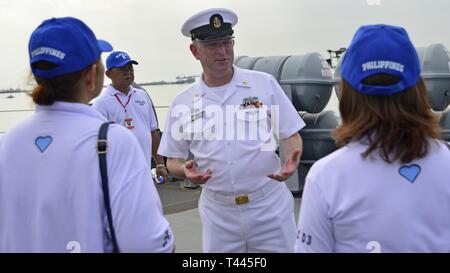 Manille, Philippines (17 mars 2019) - Spécialiste de la communication de masse en chef Charles Ludwig, de Houma, en Louisiane, mène une tournée à bord de navire amiral de la flotte 7 USS Blue Ridge (CAC 19) pour les citoyens de la ville de Quezon barangay de Blue Ridge 'B'. Blue Ridge est le plus ancien navire opérationnel dans la marine et, en tant que navire de commandement 7e Flotte, travaille activement pour favoriser les relations avec les alliés et partenaires dans la région Indo-Pacifique. Banque D'Images