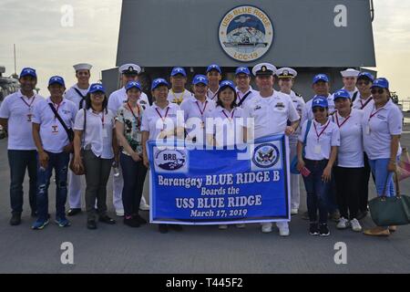 Manille, Philippines (17 mars 2019) - Les Marins attachés à 7e flotte américaine navire amiral USS Blue Ridge (CAC 19) posent pour une photo avec les membres de la ville de Quezon barangay de Blue Ridge 'B' à la fin d'un tour de bateau. Blue Ridge est le plus ancien navire opérationnel dans la marine et, en tant que navire de commandement 7e Flotte, travaille activement pour favoriser les relations avec les alliés et partenaires dans la région Indo-Pacifique. Banque D'Images