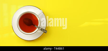 Photo - mise à plat en porcelaine blanche tasse avec cuillère remplie d'ambre chaud, thé jaune sur l'échelle du conseil, l'espace de bannière pour le texte à droite Banque D'Images
