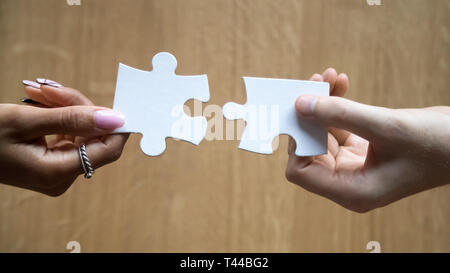 Diversité de l'homme et la femme hands holding se joindre à pièces de casse-tête de raccordement Banque D'Images