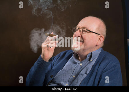 Un homme plus âgé bénéficiant d'un bon cigare fumeur Banque D'Images