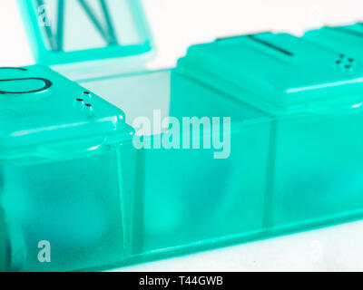 Extreme close up de sept jour comprimé fort avec des pilules. Comprimé vert-box avec mardi comprimés visible. Ouvrez la boîte de pilules sur fond blanc Banque D'Images