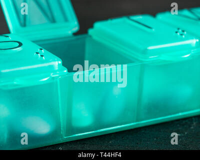 Extreme close up de sept jour comprimé fort avec des pilules. Comprimé vert-box avec mardi comprimés visible. Ouvrez la boîte de pilules sur fond noir Banque D'Images