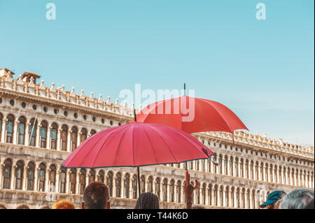 Parapluies rouges de guider des visites guides sur l'arrière-plan de la Piazza San Marco à Venise. Destination touristique. Close up. Banque D'Images