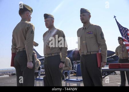 Golfe Arabique (fév. 19, 2019) U.S. Marine Corps Cpl. Robert Conely, gauche, une analyse des systèmes de données avec la 22e unité expéditionnaire maritime actuel, à l'attention après avoir reçu son certificat de fin de cours pour les caporaux dans le poste de pilotage de la classe Wasp-navire d'assaut amphibie USS Kearsarge (LHD-3). Bien sûr les caporaux est une classe de leadership conçu pour enseigner les fondamentaux de Marines est un noncomissioned direction et les préparer à prendre plus de responsabilités au sein de leur unité. Marines et de marins avec la 22e MEU et groupe amphibie Kearsarge sont déployés à la 5e flotte un Banque D'Images