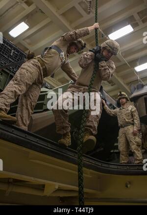 Mer Méditerranée, 10 févr. 22, 2019 - Marines et de marins avec la 22e Marine Expeditionary Unit train rapide à la corde avec dans l'espace de rangement du véhicule à bord du San Antonio-classe de transport amphibie USS station d'Arlington (LPD 24), le 22 février 2019. L'USS Arlington fait un déploiement prévu dans le cadre de la 22e MEU et le groupe amphibie Kearsarge, à l'appui d'opérations de sécurité maritime, d'intervention en cas de crise et le théâtre de la coopération en matière de sécurité, tout en offrant une présence navale et maritime. Banque D'Images