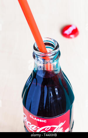 Moscou, Russie - le 4 avril 2019 : ouvrir la bouteille en verre de Coca-Cola boisson avec paille rouge et couronne utilisé pac. Coca-Cola (coke) gazéifiée sof Banque D'Images