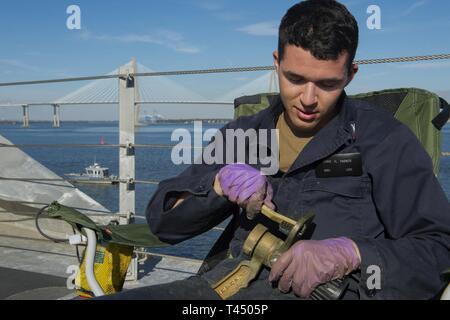 CHARLESTON, CAROLINE DU SUD (fév. 25, 2019) 3ème classe Mineman Chris H. Parker, de Chesapeake, en Virginie, s'occupe de l'entretien d un tuyau d'incendie à bord de la buse l'avenir USS Charleston (LCS) 18. Quand le Charleston est commandé dans sa ville éponyme plus tard cette semaine, ce sera le 16e navire de combat littoral à entrer dans la flotte et la neuvième de la variante de l'indépendance. Il est le sixième navire nommé pour Charleston, la plus ancienne et la plus grande ville de l'Etat américain de Caroline du Sud. Banque D'Images