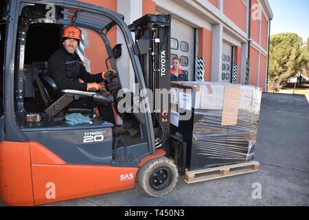 Emiliano Falca Camp Darby, employé de l'entrepôt du Programme d'assistance humanitaire sur les charges de la quarante-cinq pieds de marchandises expédiées à l'appui de l'viv les femmes et la rehabilitation centre situé à Zhytomyr, Ukraine. Cet excédent de demande de propriété est de soutenir la rénovation de la DoD 2008 Centre de réadaptation. Contribuer à la cause de l'équipement ont été achetés localement par des éléments du programme d'assistance humanitaire de l'HAP de la communauté militaire de Camp Darby Meubles de bureau de gestion consolidé (CFMO), le moral du bien-être social des loisirs (MWR), et les services de la jeunesse, et Darby point Banque D'Images