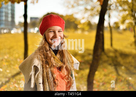 Automne portrait of a cute girl in a red hat et l'enduire avec un foulard happy smiling adolescent. Banque D'Images