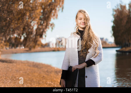 Portrait de belle jeune fille en uniforme d'adolescent est titulaire d'ordinateur portable. dans la nature près du lac Banque D'Images