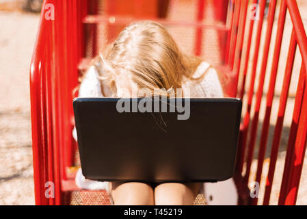 L'élève est fatigué de l'ordinateur portable. élève faire leurs devoirs dans le parc sur l'escalier rouge Banque D'Images