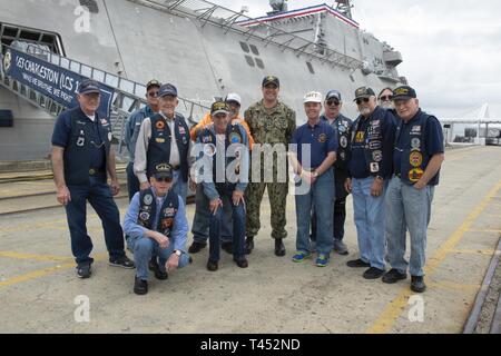 CHARLESTON, CAROLINE DU SUD (fév. 27, 2019) Le Cmdr. Christopher K. Brusca, centre, commandant de l'USS Charleston (futur LCS 18), et originaire de Los Angeles, pose pour une photo avec les membres de l'étain peut marins Association nationale des anciens combattants pendant un navire destroyer visite. LCS 18 est prévu pour être commandé à Charleston le 2 mars et sera le 16e navire de combat littoral à entrer dans la flotte et la neuvième de la variante de l'indépendance. Il est le sixième navire nommé pour Charleston, la plus ancienne et la plus grande ville de l'Etat américain de Caroline du Sud. Banque D'Images