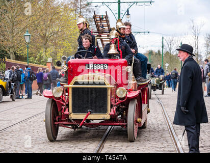 Beamish, comté de Durham, Angleterre, Royaume-Uni, 13 avril 2019. Jour : un vapeur Beamish vintage 1916 Dennis rouge feu ouvert en haut du véhicule moteur avec des hommes habillés en costumes d'époque les pompiers à l'affiche au Musée vivant de Beamish Banque D'Images