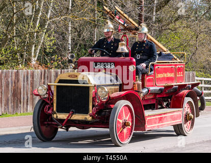 Beamish, comté de Durham, Angleterre, Royaume-Uni, 13 avril 2019. Jour : un vapeur Beamish vintage 1916 Dennis rouge feu ouvert en haut du véhicule moteur avec des hommes habillés en costumes d'époque les pompiers à l'affiche au Musée vivant de Beamish Banque D'Images