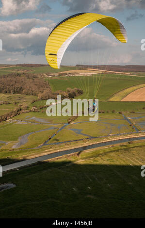 Seaford, East Sussex, Royaume-Uni. 13 avril 2019. Le vent froid de l'est amène les pilotes de parapente à High & Over dans les magnifiques South Downs surplombant la rivière Cuckmere. Banque D'Images