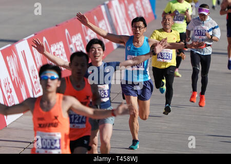 Beijing, Chine. 14 avr, 2019. Les participants ont franchi la ligne d'arrivée lors de la Demi-marathon de Beijing 2019 à Beijing, capitale de Chine, le 14 avril 2019. Credit : Ju Huanzong/Xinhua/Alamy Live News Banque D'Images