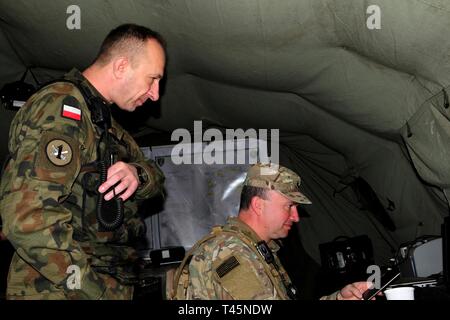 L'ARMÉE AMÉRICAINE Cpt. James Nelson, affecté à la 56e Infantry Brigade Combat Team, Texas Army National Guard, effectue des tâches d'observateur/formateur-Coach avec un soldat polonais pendant 19 avant dynamiques à Torun, Pologne, le 6 mars 2019. Avant dynamiques exercice 19 comprend environ 3 200 militaires de 27 nations qui s'observer ou participer à partir de la zone d'entraînement Grafenwoehr, Allemagne ; Riga, Lettonie ; et Torun, Pologne ; en mars 2-9, 2019. Avant dynamique est un exercice annuel de l'Europe de l'armée américaine a porté sur l'état de préparation et l'interopérabilité de l'armée américaine, service commun, et des alliés et partenaires nati Banque D'Images