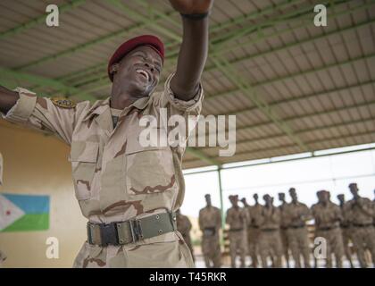 Bataillon d'intervention rapide (RIB) des soldats de l'armée djiboutienne la force militaire d'élite exécuter une danse après un sous-officier à l'obtention du diplôme du cours de formation d'un emplacement près de Djibouti, le 7 mars 2019. Des soldats américains avec 1 à 26 Bataillon d'infanterie, 2e Brigade Combat Team, la 101e Airborne, affecté à la Force opérationnelle combinée Force-Horn de l'Afrique, a enseigné le cours de la nervure des soldats.