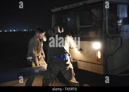 380e Escadron de maintenance des aéronefs de la Force expéditionnaire du chef d'équipe, les membres attachent le remorquer à un E-3 Sentry en taxi à la base aérienne d'Al Dhafra, aux Émirats arabes unis, le 7 mars 2019. Ces inspections permettent aux aviateurs pour identifier et résoudre des problèmes avec l'avion. Banque D'Images