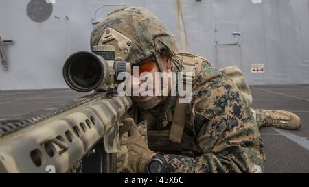 Océan Pacifique (fév. 20, 2019) Le sergent du Corps des Marines des États-Unis. Benjamin Westmoreland, un chef scout sniper avec des armes, de l'entreprise Équipe de débarquement du bataillon du 3e Bataillon, 5e Régiment de Marines, 11e Marine Expeditionary Unit (MEU), sites de derrière un spécial de calibre 50 avec lunette de visée des applications à bord de la classe San Antonio-dock transport amphibie USS John P. Murtha (LPD 26). Les Marines et les marins du 11e MEU mènent des opérations de routine dans le cadre du groupe amphibie Boxer dans l'océan Pacifique. Banque D'Images